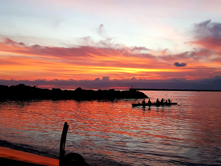 An amazing caption of the sunset in winter days over the sea of Genova with beautiful red sky and some amazing clouds in the backgroundの写真素材