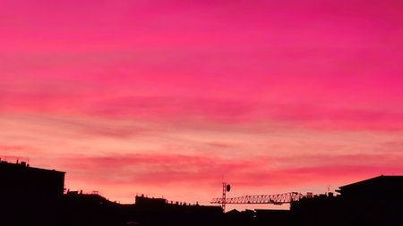 Genova, Italy - January 1, 2021: An amazing photography of the sunset in winter days over the sea and the port of Genova with beautiful red sky and some amazing colored clouds in the background.のeditorial素材