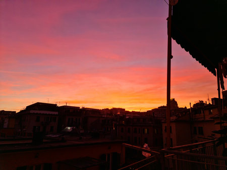 Genova, Italy - January 1, 2021: An amazing photography of the sunset in winter days over the sea and the port of Genova with beautiful red sky and some amazing colored clouds in the background.のeditorial素材