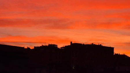 Genova, Italy - January 1, 2021: An amazing photography of the sunset in winter days over the sea and the port of Genova with beautiful red sky and some amazing colored clouds in the background.のeditorial素材
