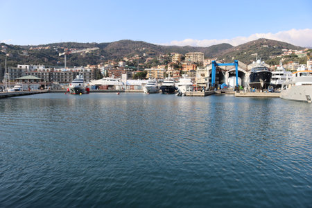 SAVONA, ITALY - February 12, 2022 - The port of Savona in the heart of the city on the italian riviera. Some old  container lifter near the new area. Beautiful small boats parked.のeditorial素材