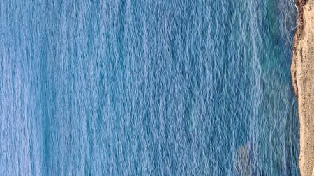 Savona, Italy - February 12, 2022: Panorama of the blue sea, light above the water, ocean sunrise....