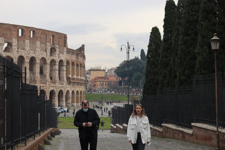 ROME, ITALY - February 05, 2022: Panoramic view around the Colosseum in city of Rome, Italy. Cold and gray sky in the background. Macro photography of the green parks with the old buildings.のeditorial素材