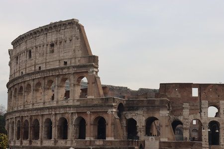 ROME, ITALY - February 05, 2022: Panoramic view around the Colosseum in city of Rome, Italy. Cold and gray sky in the background. Macro photography of the green parks with the old buildings.のeditorial素材
