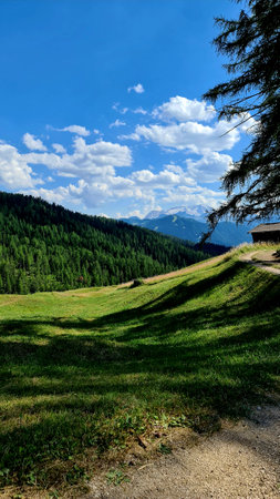 Val Badia, Italy-July 18, 2022: The italian Dolomites behind the small village of Corvara in summer days with beaitiful blue sky in the background. Green nature in the middle of tの写真素材