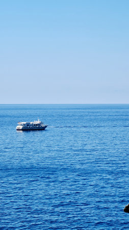 Genova, Italy- July 27, 2022: Panorama of the blue sea, light above the water, ocean sunrise. Some little waves in winter days. Clear sky reflected on the water.の写真素材