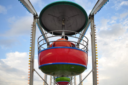 the swing cable basket ferris wheel on blue sky cloud background at amusement park is the family vacation activity on holidayの写真素材