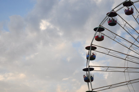 the swing cable basket ferris wheel on blue sky cloud background at amusement park is the family vacation activity on holidayの写真素材