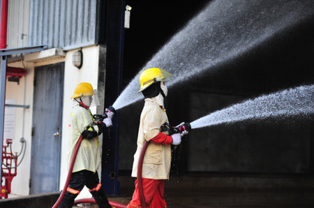 the group of firefighters man are inject spray the water to fire accident on buildingの写真素材