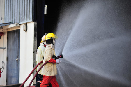 the group of firefighters man are inject spray the water to fire accident on buildingの写真素材