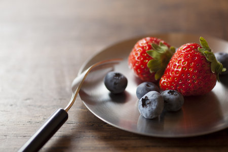 strawberries and blueberries on the wood tableの写真素材