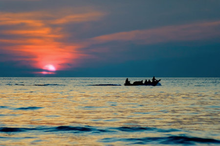 sunset with boat silhouetteの写真素材