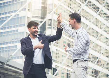 Young of caucasian businessman greeting/meeting and show thumbs up in the modern city, teamwork and happy cooperation concept.の写真素材