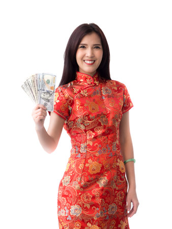 Chinese new year woman concept, isolated asian woman wearing red dress holding dollars moneyの写真素材