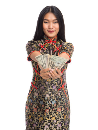 Chinese new year woman concept, isolated asian woman wearing red dress(cheongsam) holding dollars moneyの写真素材