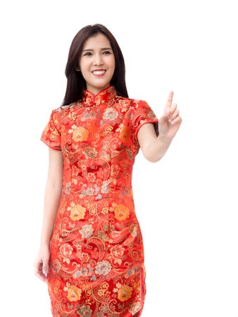 Chinese new year woman concept, isolated asian woman wearing red dress with finger pointing actingの写真素材