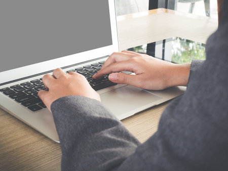 Businesswoman using laptop computer, writing email to customer, working on mock up laptop isolated screenの写真素材