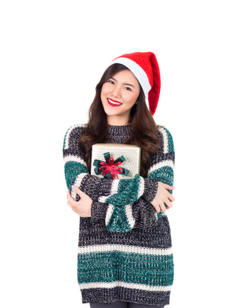 Young happy asian woman with santa hat holding gift box present for christmas party and celebration isolated on white background, merry christmas and happy new year conceptの写真素材
