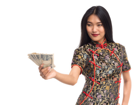 Chinese new year woman concept, isolated asian woman wearing red dress(cheongsam) holding yuan moneyの写真素材