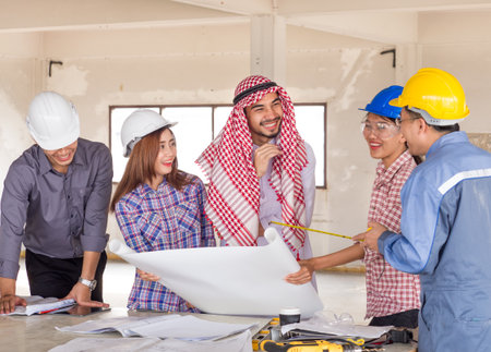 Engineer, architect and arab businessman planing for project construction building, talking and discuss on drawing blueprint plan, working with happy feelingの写真素材