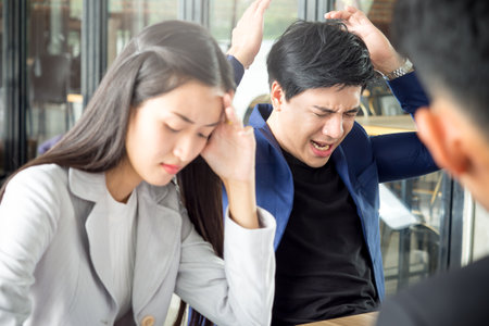 Stressed angry crazy asian business man and woman feeling upset, disappointed during meeting, knowing bad news at cafe officeの写真素材