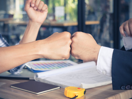 Two of businessman and engineer/architect giving Fist bump or Knuckle bump  during Meeting  for success and agreement to express teamwork/togetherness andの写真素材