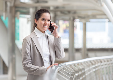 Portrait young caucasian businesswoman 20-30s holding smart phone/cell phone/mobile in formal suit at the modern cityの写真素材