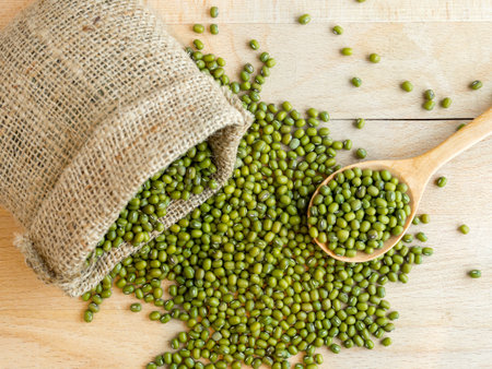 Mung beans(green beans) in a sack, on wood backgroundの写真素材