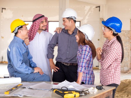 Engineer, architect and arab businessman planing for project construction building, talking and discuss on drawing blueprint plan, working with happy feelingの写真素材