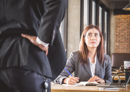 Aggressive/angry boss complaining asian business woman(casual uniform) in cafe officeの写真素材