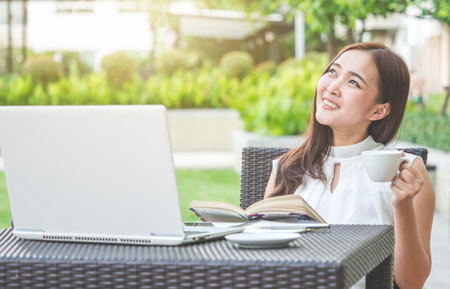 Young beautiful Asian woman working with laptop/internet/online shopping at outdoor park, smile/fresh and happy relaxing feeling in the morning, freelancer working businesswoman lifestyle conceptの写真素材