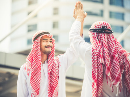 Greeting of arab businessman in the modern city, successful, happy, good feeling, winner, hi five actingの写真素材
