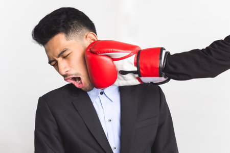 Boss punching employee by red boxing glove, business punishment and fighting concept.の写真素材