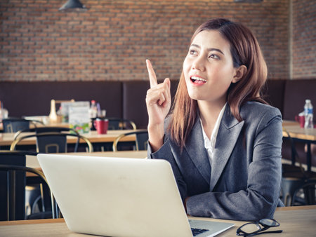Young asian businesswoman having an idea during working with laptop at cafeの写真素材