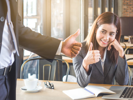 Boss/employer admires to young Asian businesswoman/staff/employee with smiling face for her success and good/best in work.の写真素材
