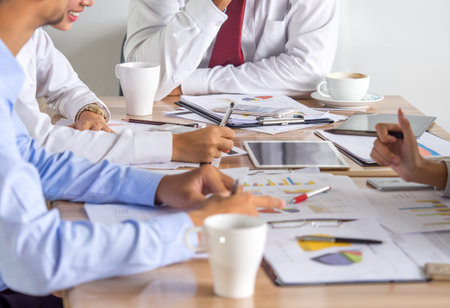 Meeting table/desk, businessman talking about business plan, progress report for business work, financial report, status, tablet, meeting, on the table, discussing with colleague at officeの写真素材