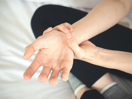 Asian woman pain at wrist, arm and hand, feel ache, Inflammation, woman muscle pain conceptの写真素材