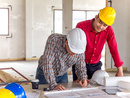 Engineer/architect/worker man discussing about building plan for construction at job site, working...