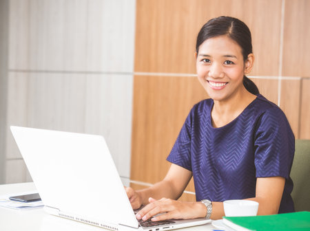 Young asian businesswoman working on laptop at office during, smiling and happy working.の写真素材