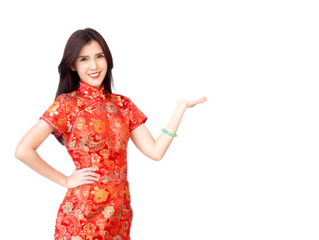 Chinese new year woman concept, isolated asian woman wearing red dress Cheongsam welcome actingの写真素材