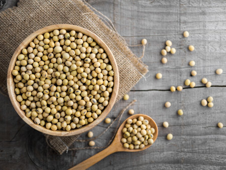 Soy beans in a wooden bowl on wooden background with sack, soy beans on wooden spoon with sack.の写真素材