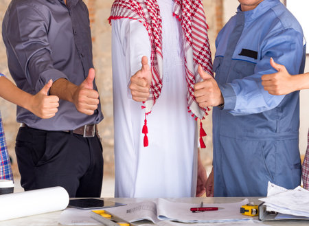 Engineer, architect and arab businessman planing for project construction building, talking and discuss on drawing blueprint plan, working with happy feelingの写真素材