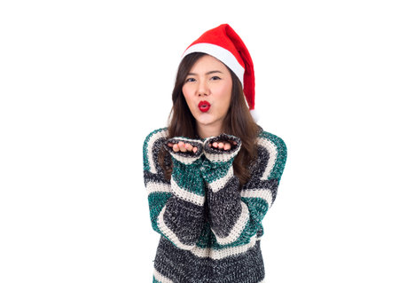 Young happy asian woman with santa hat showing kiss with hands isolated on white background, merry christmas and happy new year conceptの写真素材
