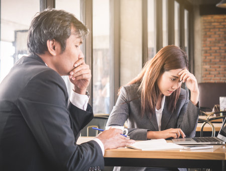 Aggressive/angry boss complaining asian business woman(casual uniform) in cafe office, meeting stressed, serious feelingの写真素材
