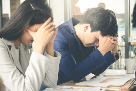 Stressed angry crazy asian business man and woman feeling upset, disappointed during meeting, knowing bad news at cafe officeの写真素材