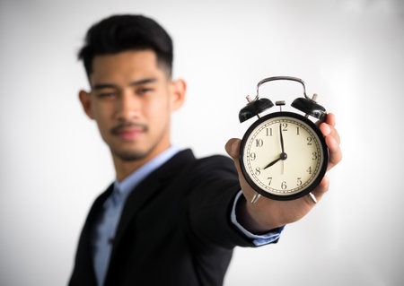 Businessman/boss/manager showing clock on white background, working time, late, punctual concept.