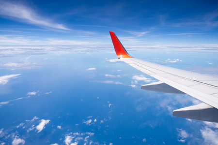 Plain wing over blue sky and sea, travel on the plain.の写真素材