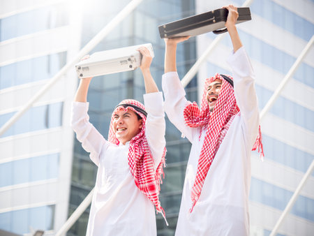 Greeting of arab businessman in the modern city, successful, happy, good feeling, winner, holding bag and risingの写真素材