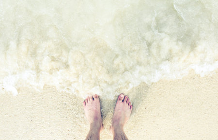Foot/feet on beach/sea water, relaxing on vacation, holiday, freedom, lifestyle.の写真素材