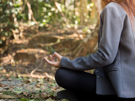 Young asian businesswoman yoga in forest, relaxing for working meditation, business lifestyle and wellbeing conceptの写真素材